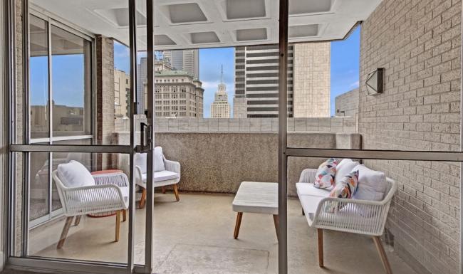 a balcony with a couch and chairs